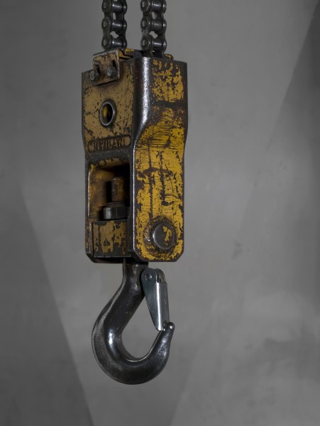 Lifting hook with a safety latch hanging from a bridge crane