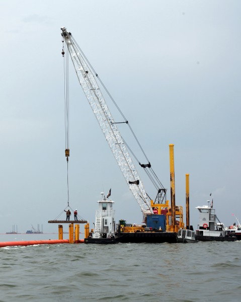 Workers assemble 36 in pipe hard boom on Barataria Bay (5014769017)