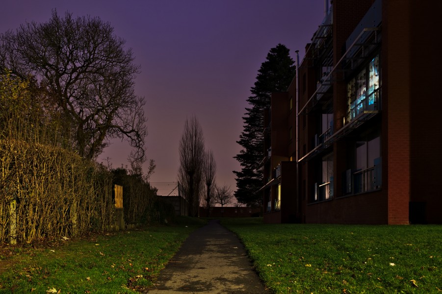 Path leading to the back of a residential appartment building North of Rue Jean Ekelmans in Auderghem, Belgium (evening nautical twilight)