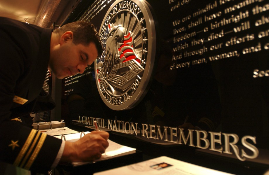 US Navy 041202-N-3659B-001 Lt. Cmdr. Samuel Delgado, Navy Recruiting^rsquo,s 2004 Reserve Diversity Recruiter of the Year, signs a visitor book at the September 11th Memorial in the Pentagon