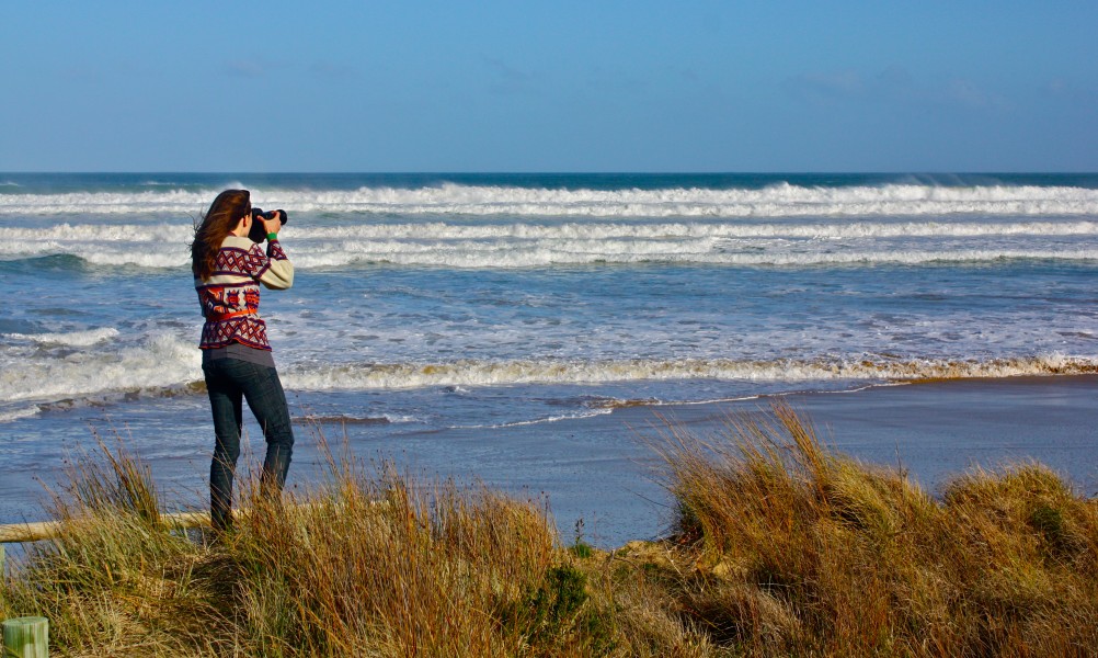 Girl photographing ocean