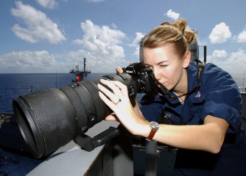 US Navy 030122-N-5786V-501 Sabrina Day from Beaufort, S.C., uses a 400mm fixed telephoto lens to photograph daily activity aboard the aircraft carrier