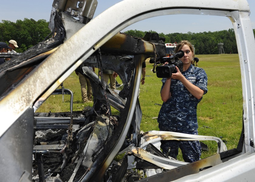 US Navy 110607-N-ZZ999-099 Mass Communication Specialist 2nd Class Kristin Grover documents damage to a vehicle and the surrounding area after the