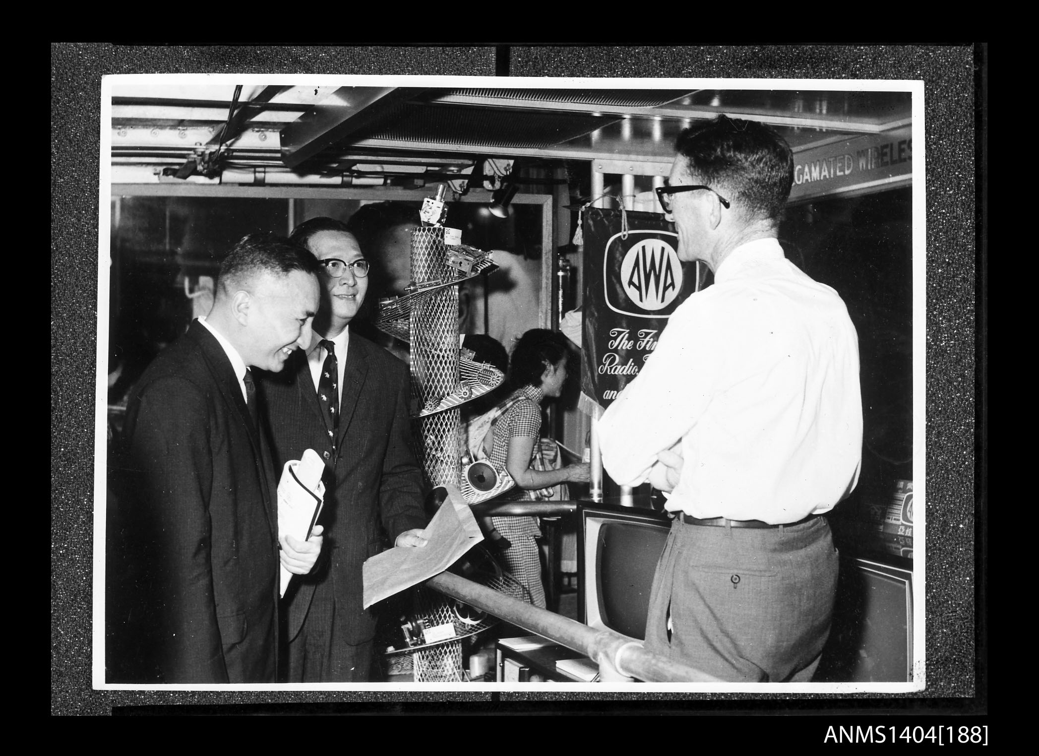 Two men looking at an AWA company display on board a trade ship (21665080355)