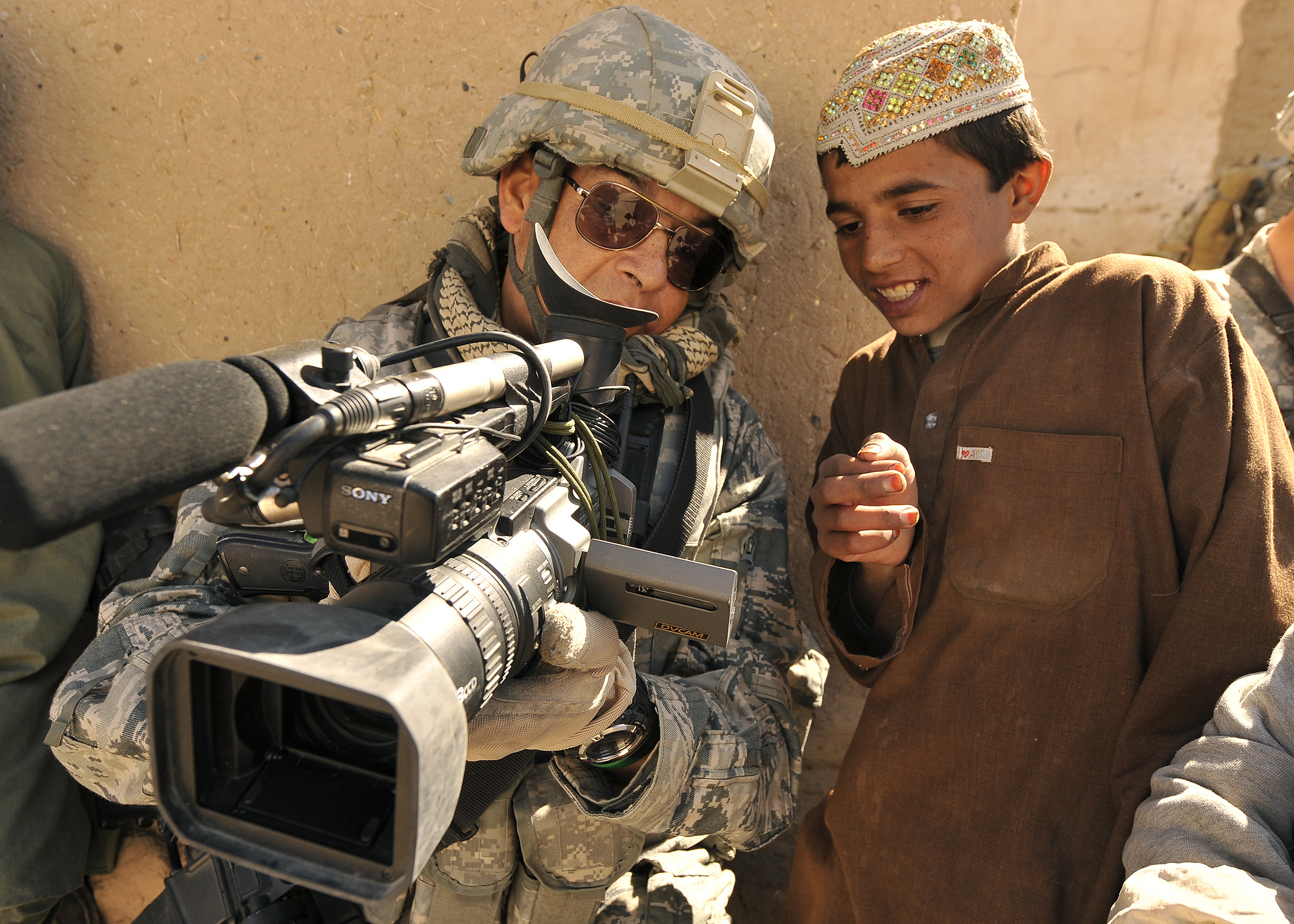 U.S. Air Force Master Sgt. Robert Carreon, with the 4th Combat Camera Squadron, shows his video recording to a student at the Wazi Muhammad Khan School in Hutal, Afghanistan, Jan. 7, 2010 100107-F-PU334-121