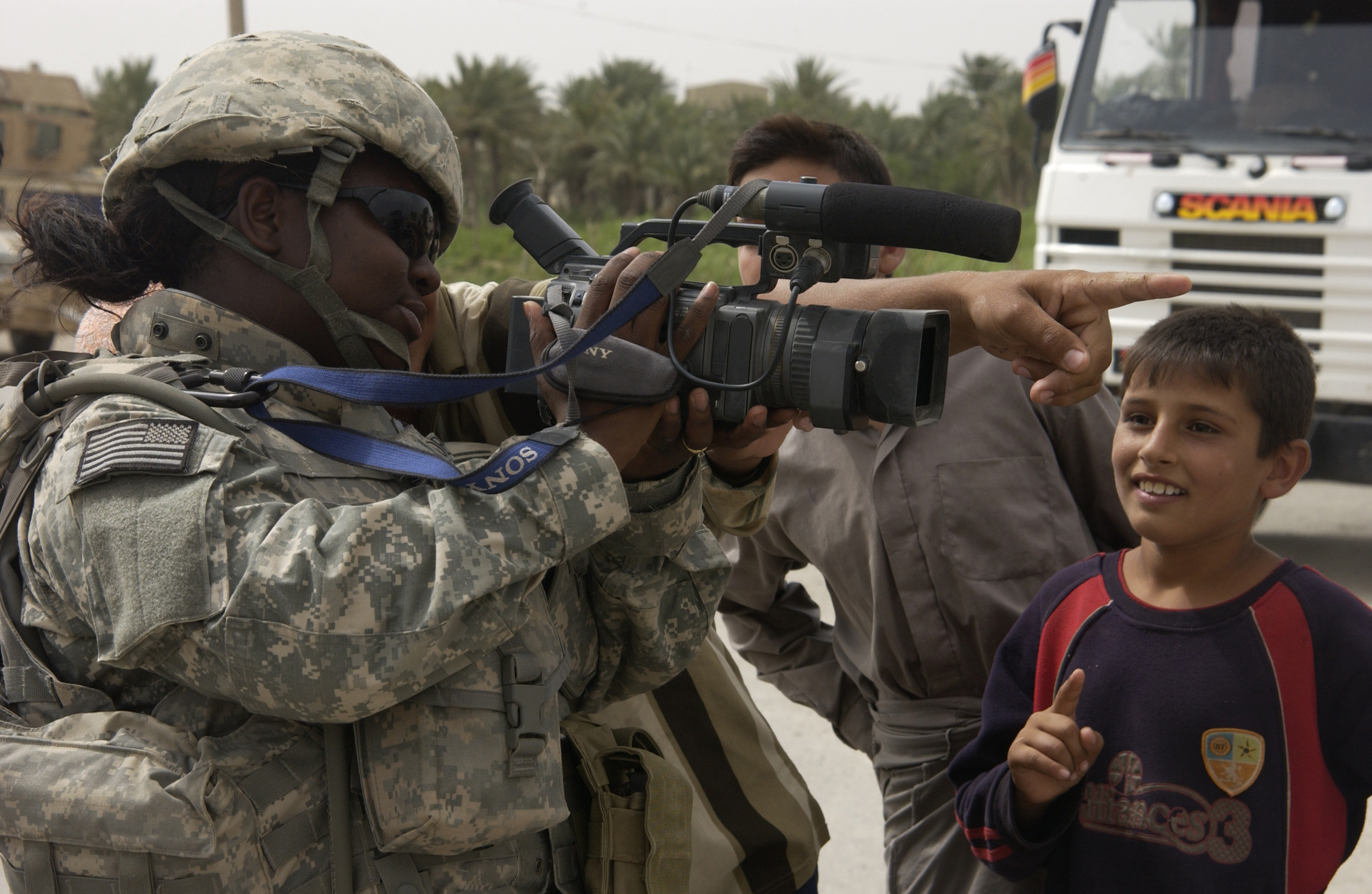 U.S. Air Force SrA Chalanda Roberts of, Joint Combat Camera, shows iraqi children what she see's through the viewfinder of her video camera at a traffic control point located near Abusayda, Iraq on June 1 070601-F-AD344-077