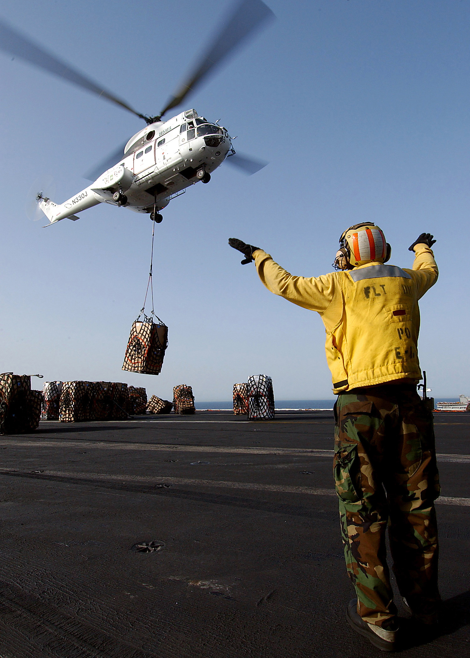 US Navy 040527-N-7871M-047 Aviation Boatswain's Mate 2nd Class Francis Gardner, of Waukegan, Ill., directs an Aerospatiale SA330 Puma helicopter after picking up a pallet of supplies