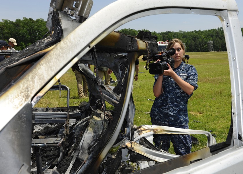 US Navy 110607-N-ZZ999-099 Mass Communication Specialist 2nd Class Kristin Grover documents damage to a vehicle and the surrounding area after the 