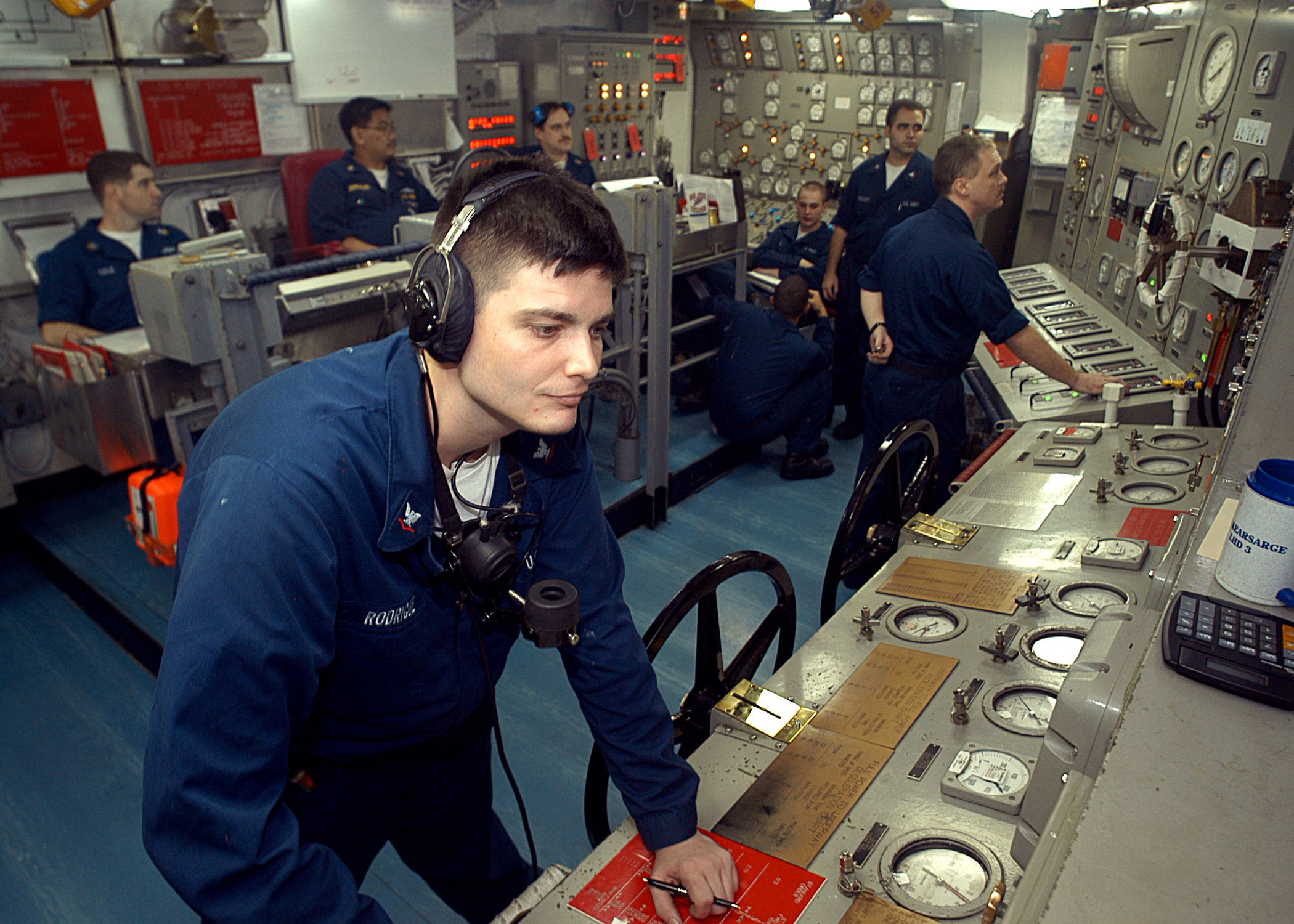 US Navy 030625-N-2819P-022 Machinist^rsquo,s Mate 3rd Class Christopher J. Rodrigue from Valentine, La., receives messages from the bridge