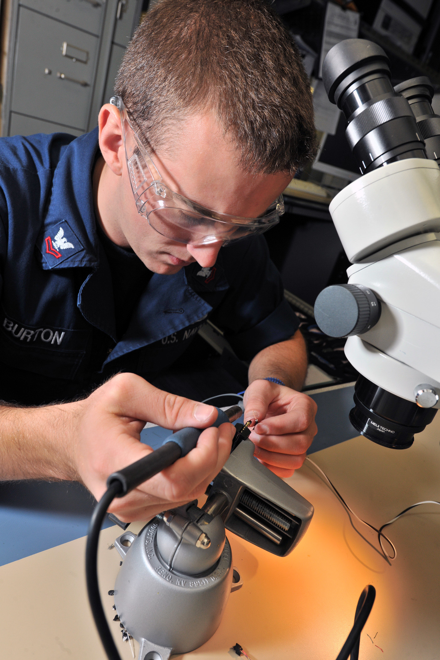 US Navy 110907-N-YZ751-036 Electronics Technician 2nd Class Aaron E. Burton prepares to solder a damaged wire aboard USS Truxtun (DDG 103)