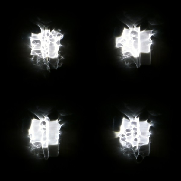 Four versions of a floodlight through rain on a window