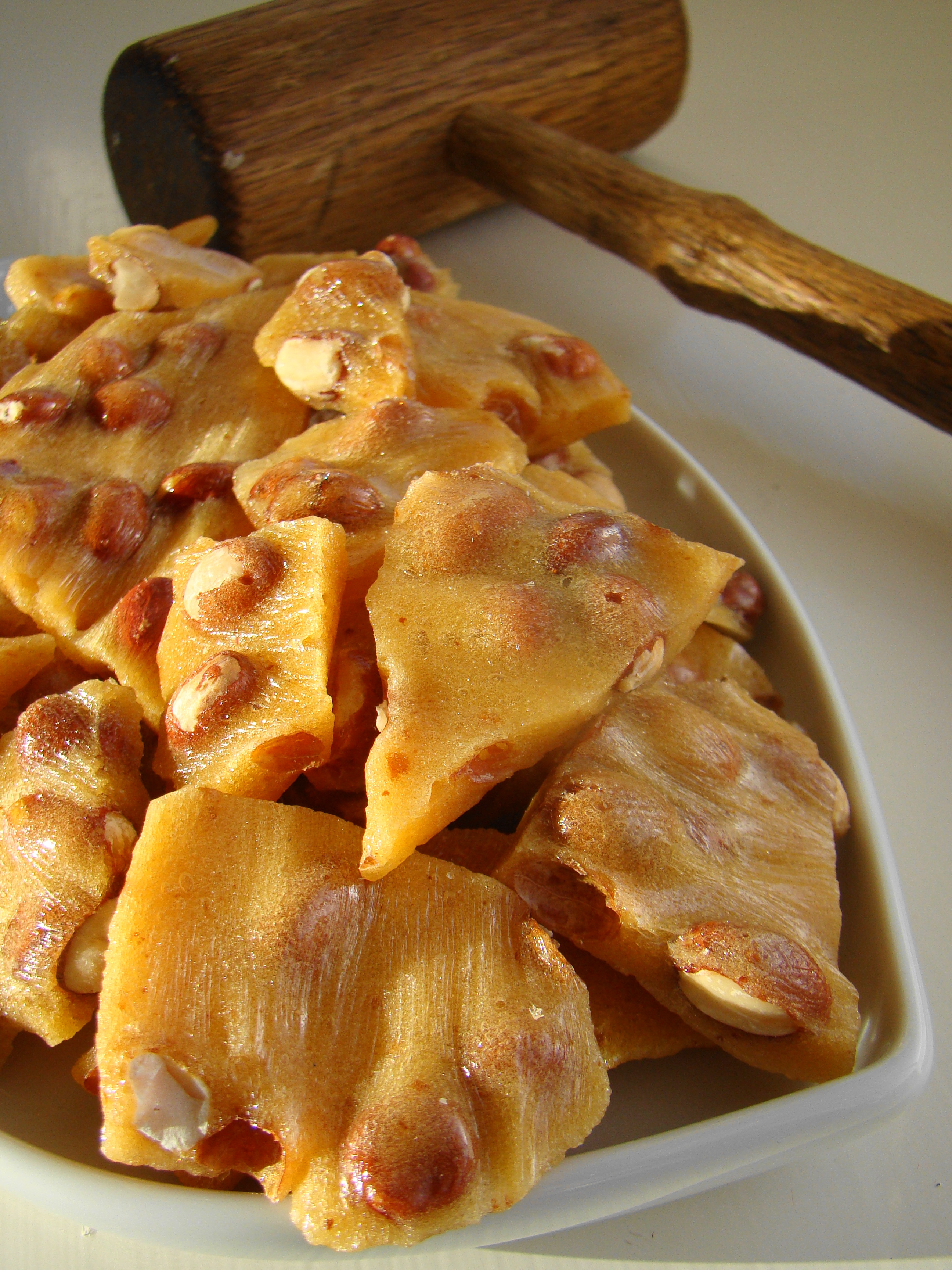 Golden peanut brittle cracked on a serving dish