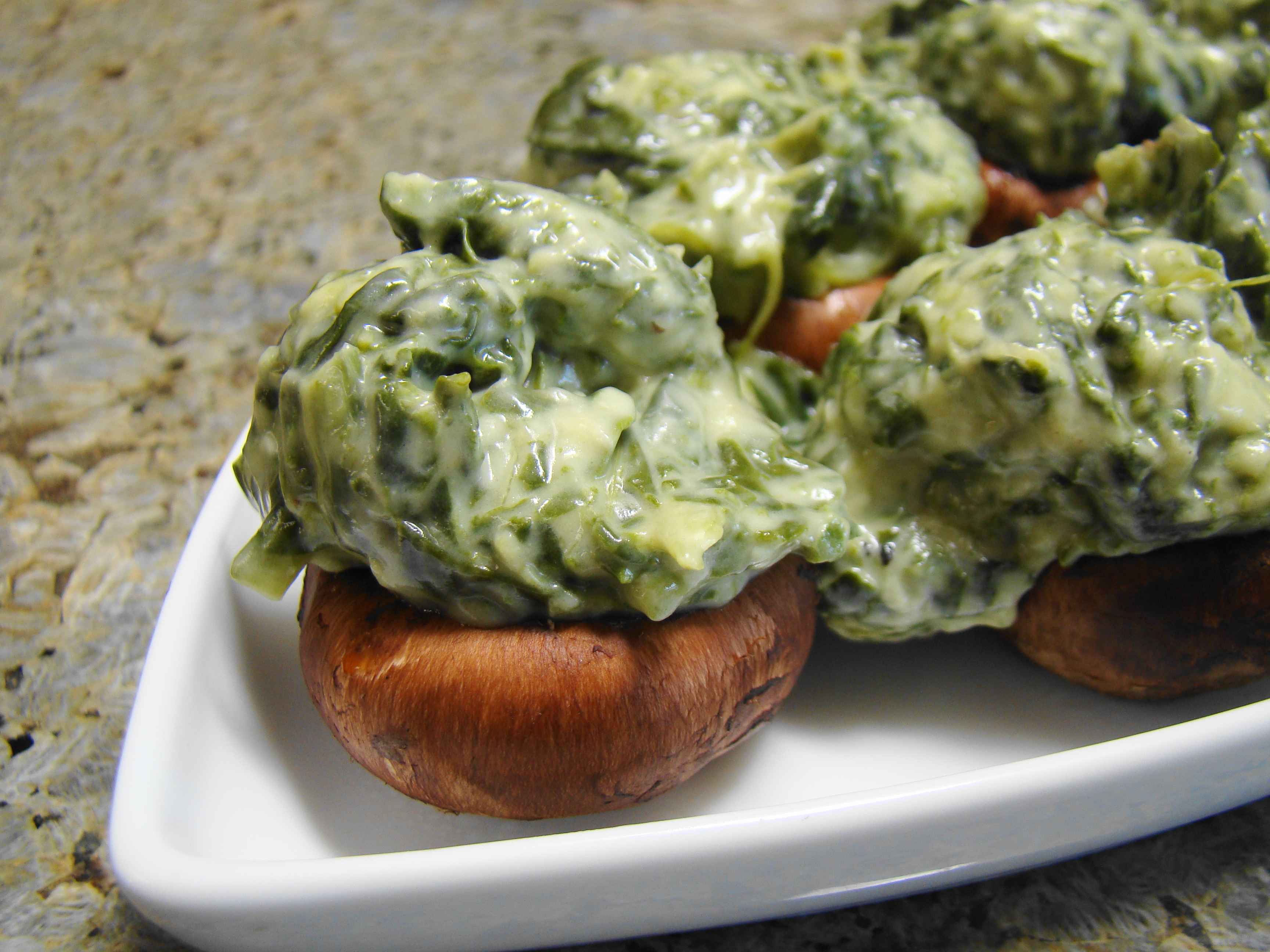 Kremed Spinach Stuffed Mushrooms on white serving dish