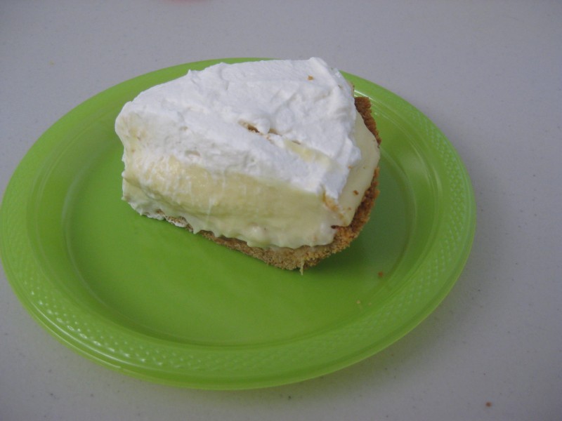 Slice of banana cream pie on green plate