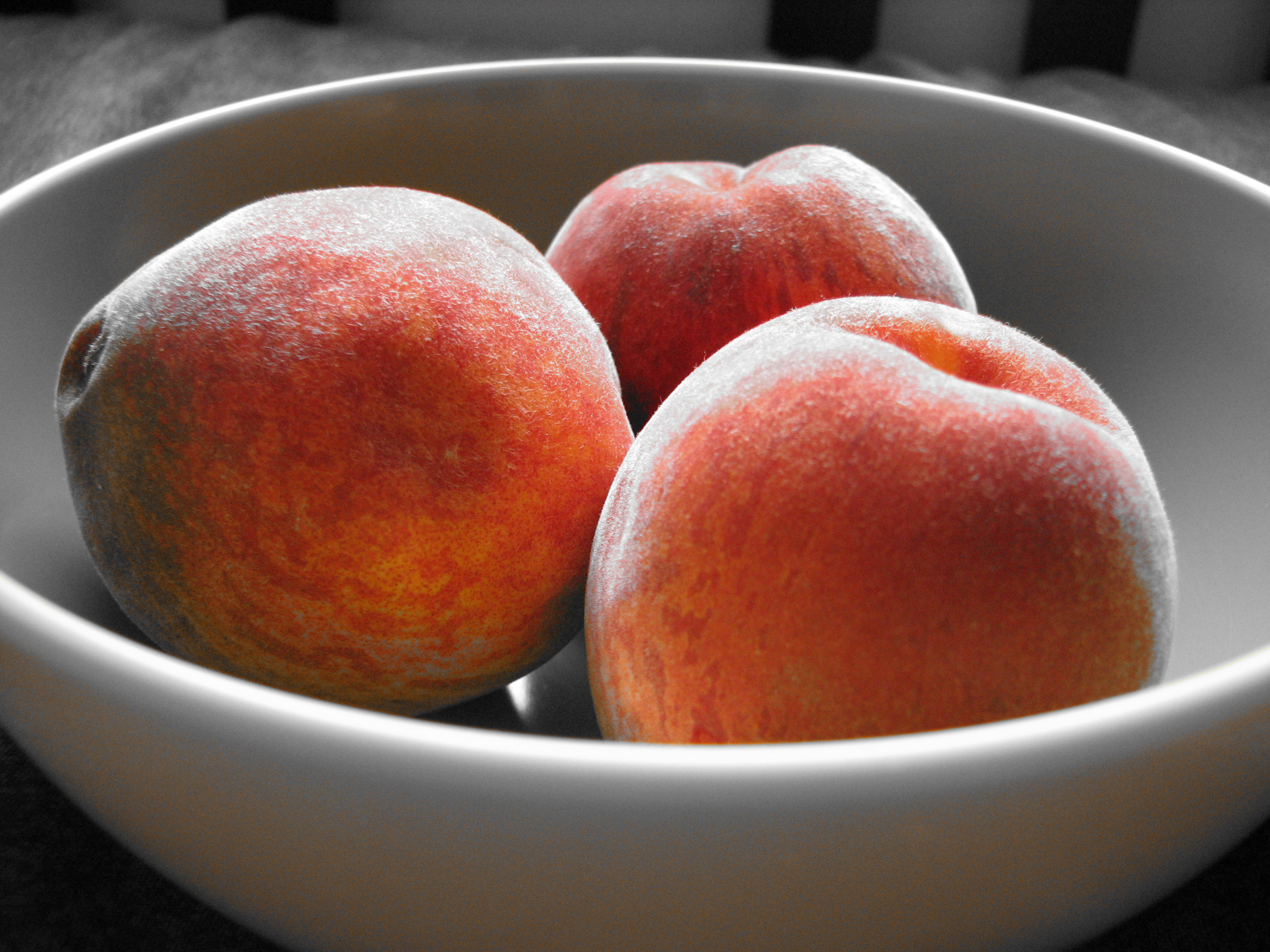 Bowl of peaches with orange accent