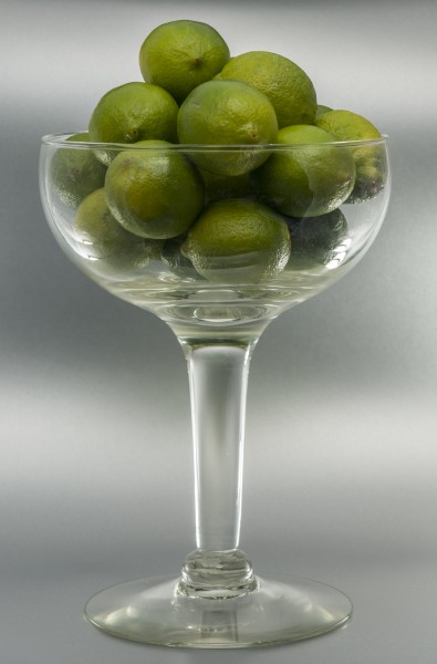 Lime fruits in tall glass bowl