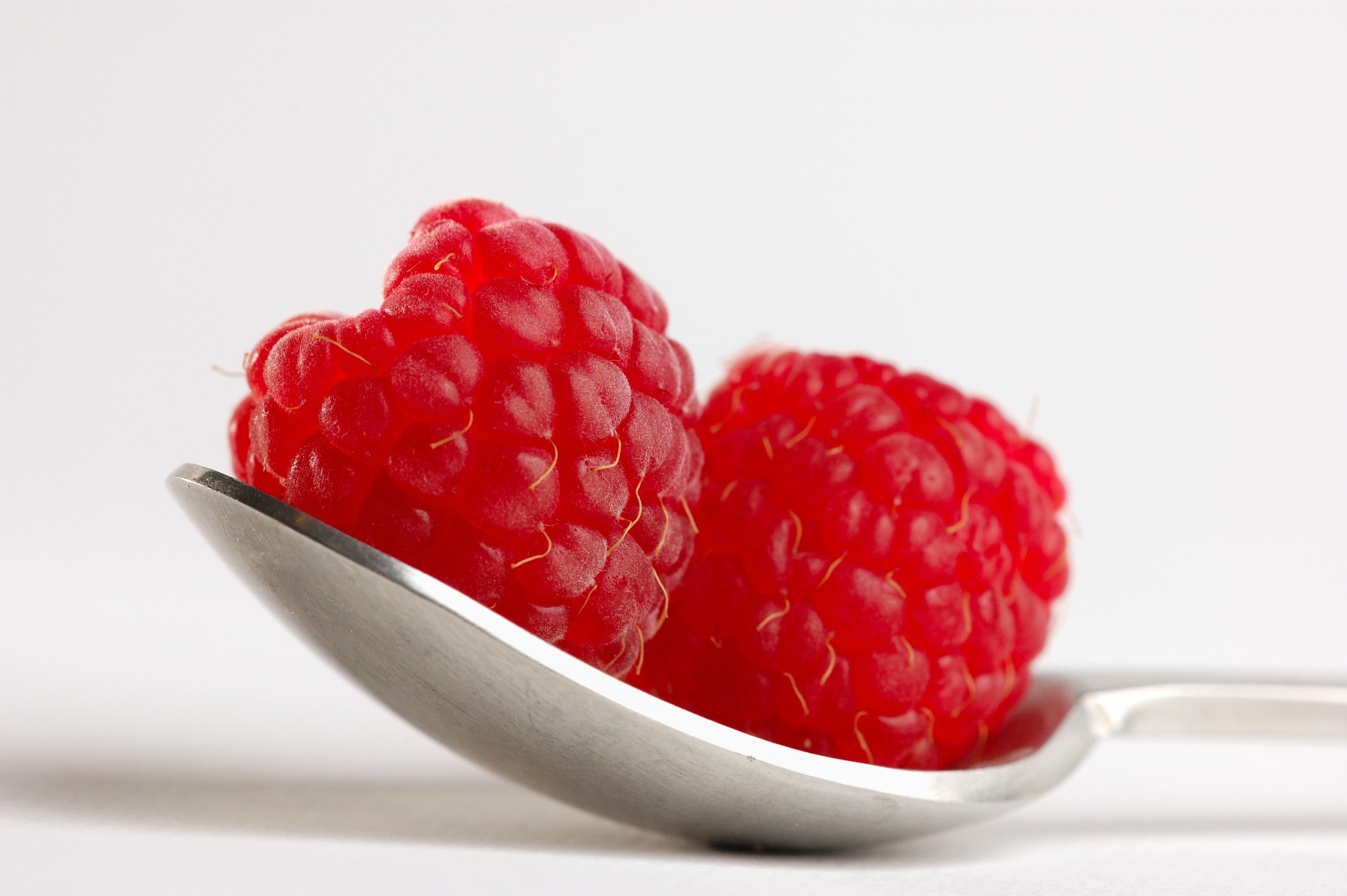 Two raspberries on a spoon