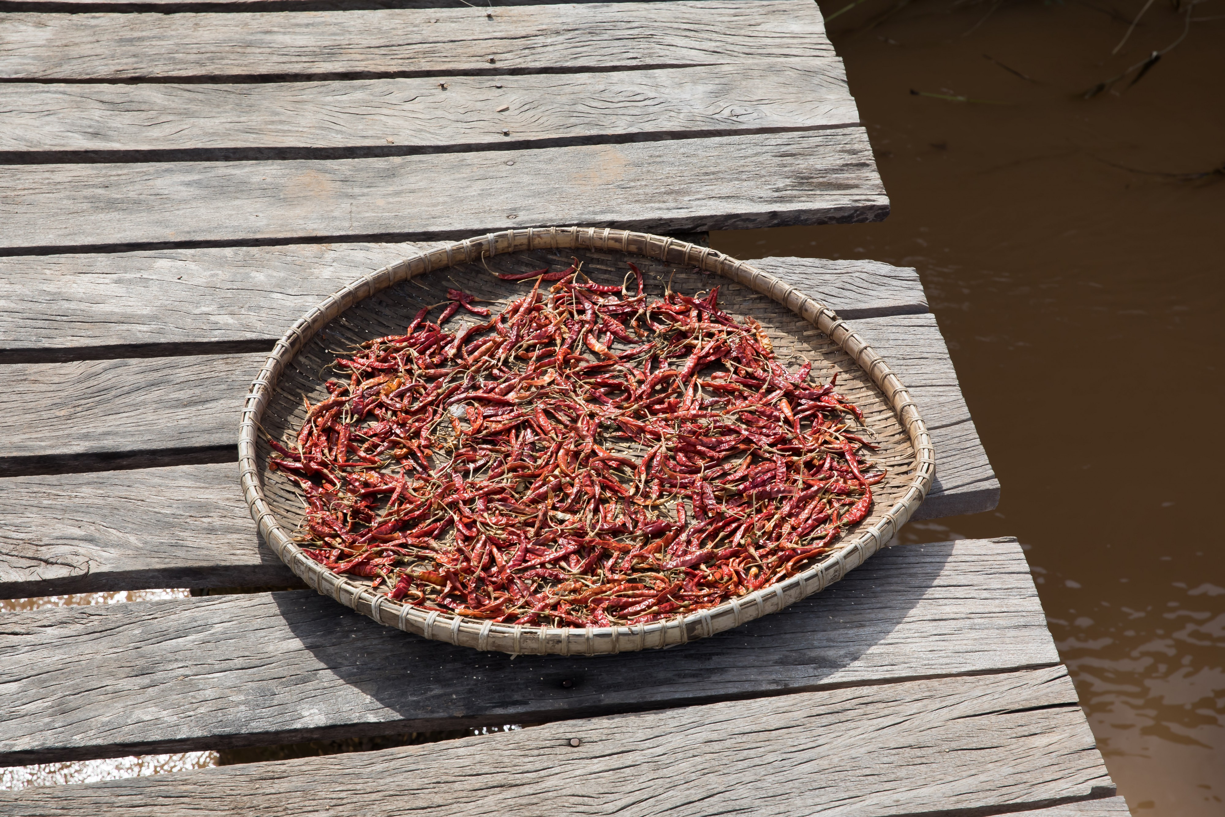 Red chili peppers drying on a footbridge