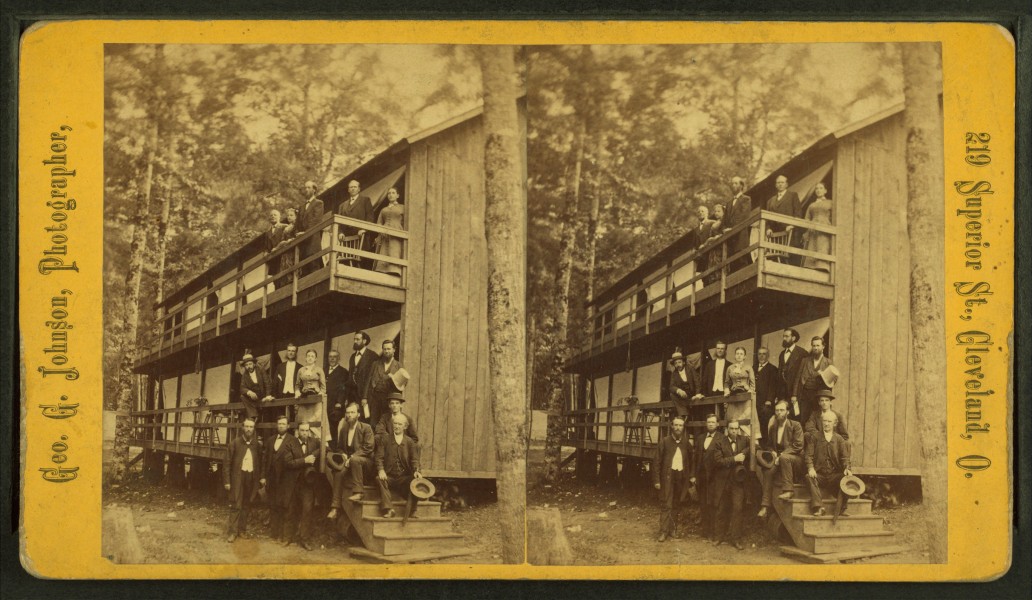A group posing on porch and balcony at campground or resort, by Geo. G. Johnson