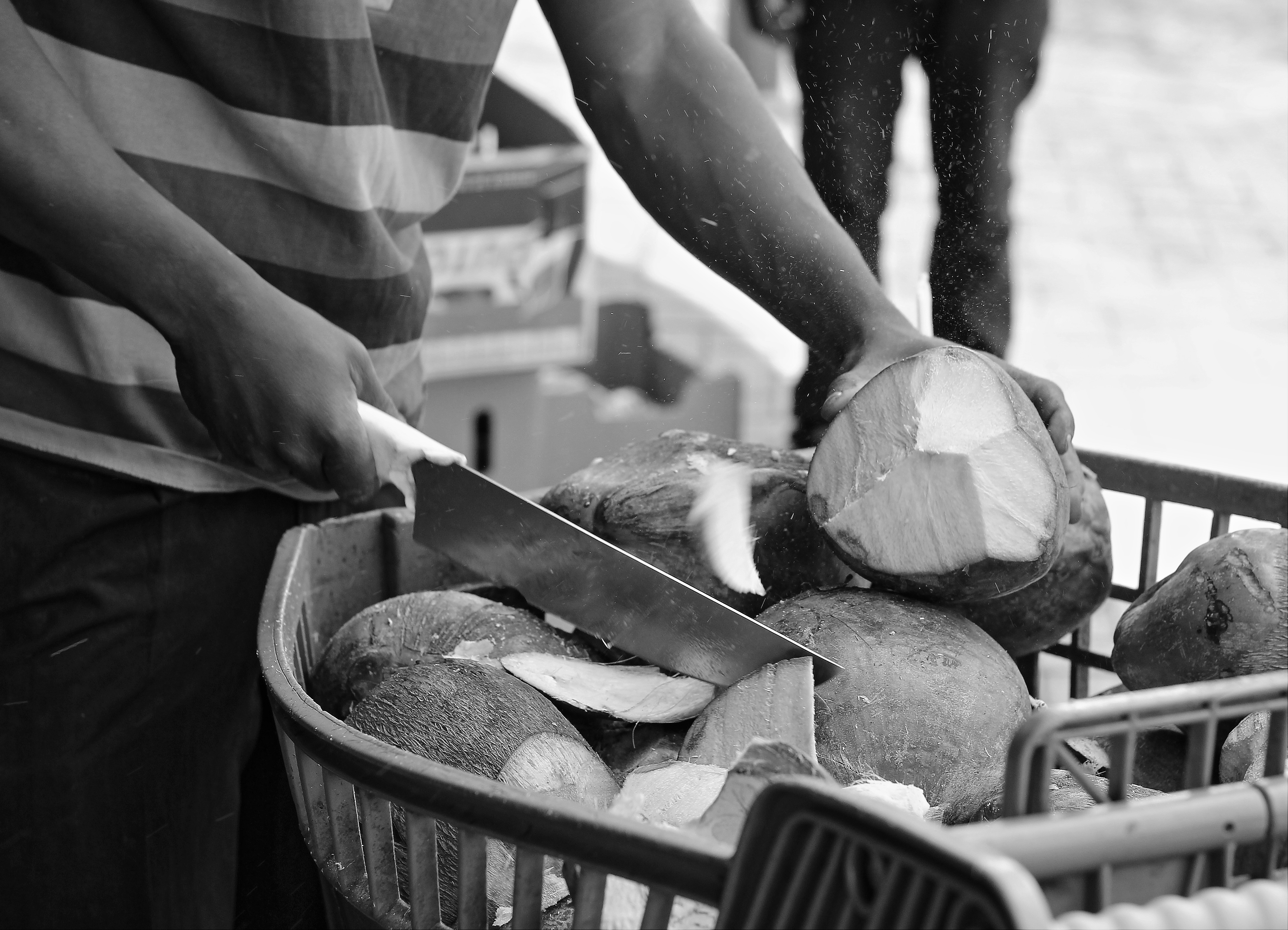 A man makes his living opening and selling coconuts on the street (Fordsburg, 2015)
