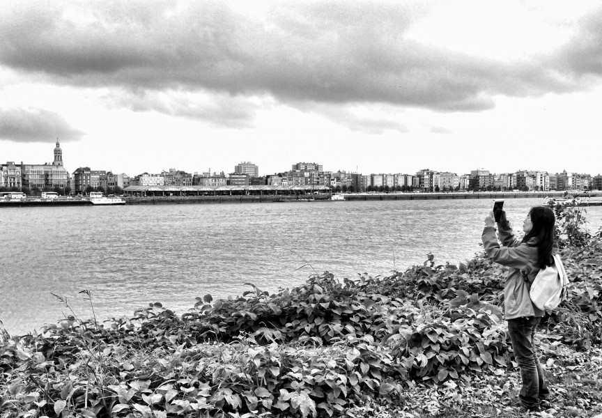 Girl taking a photo at river Scheldt by jules grandgagnage