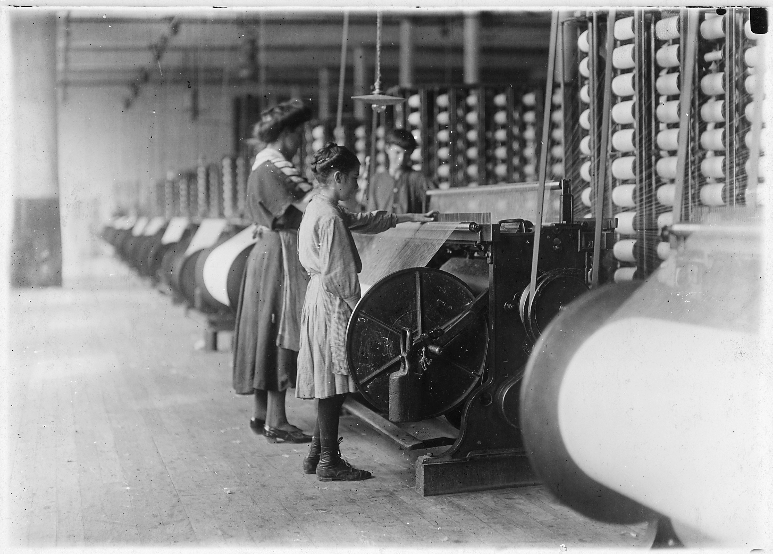 Girls running warping machines in Loray Mill, Gastonia, N.C. Many boys and girls much younger. Boss carefully avoided... - NARA - 523104