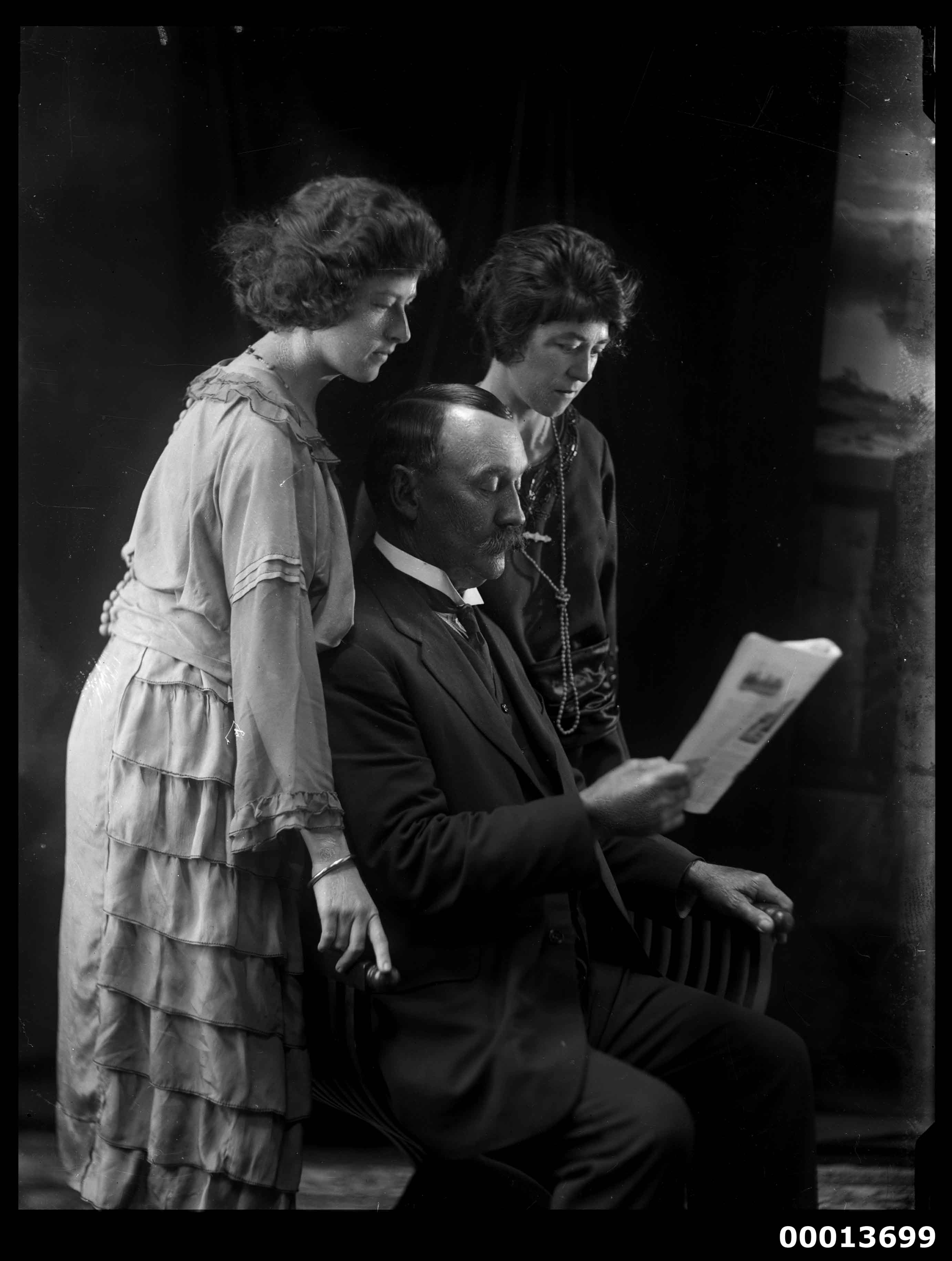 Group portrait featuring two ladies and a man reading a paper (7089495825)