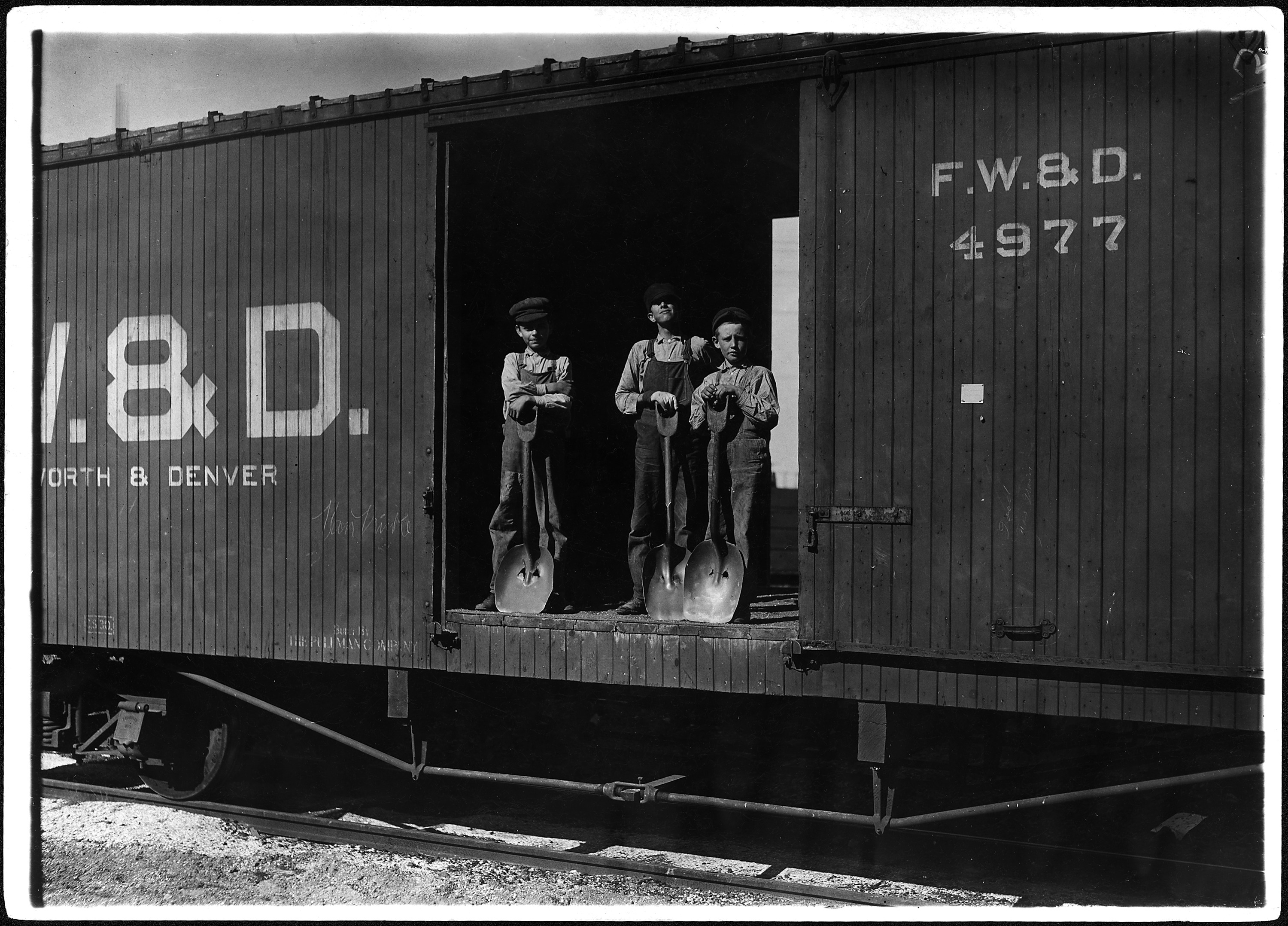 No caption. Three young boys with shovels standing in doorway of a Fort Worth ^amp, Denver train car. - NARA - 523335
