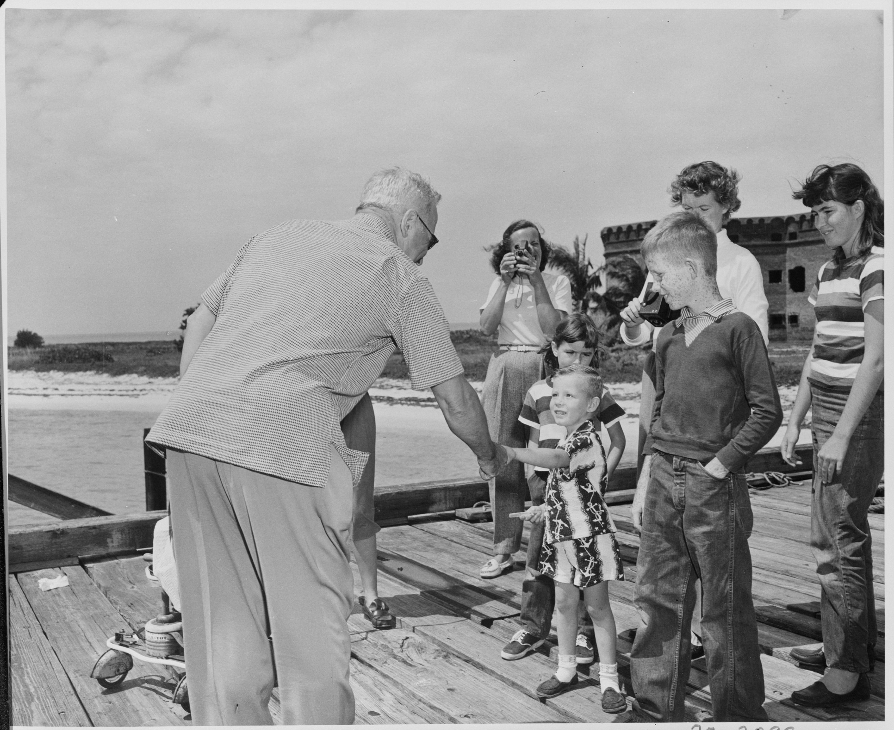 Photograph of President Truman shaking hands with a child upon his arrival at the Fort Jefferson National Monument. - NARA - 200591