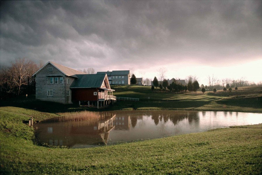Building and pond with line of stormy clouds above