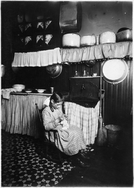 Camela, 12 years old, making Irish lace for collars. Works until 9 P.M. in dirty kitchen. New York City. - NARA - 523513