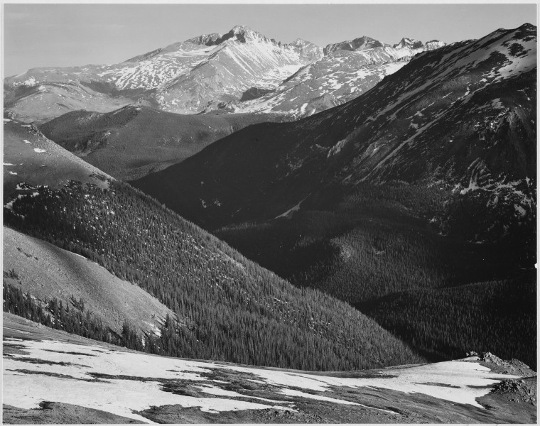 Close in view, dark shadowed hills in foreground, mountains in background, 