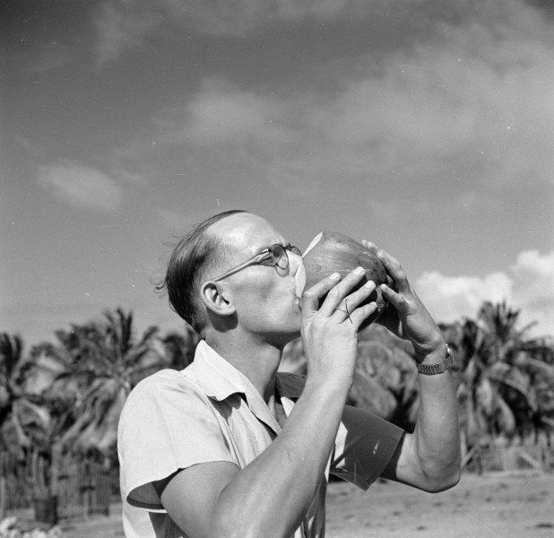 De reisgenoot van Willem van de Poll, drs Kringer, drinkt kokosmelk uit een kok, Bestanddeelnr 252-5665
