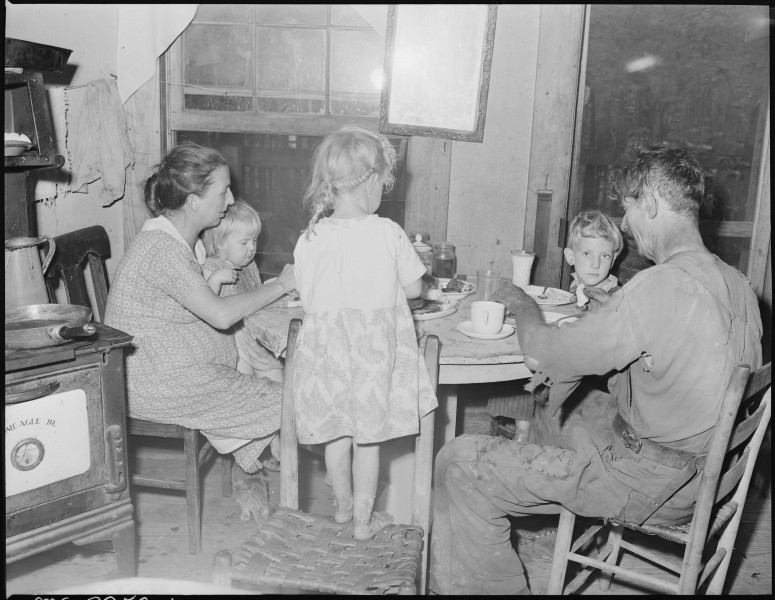 Dillard Eldridge, his wife and children, at supper in the four room house for which they pay $9 monthly. This is one... - NARA - 541209