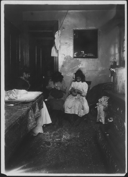 Florence, 12 years old, and her sister, Jennie, working on crochet hats in dirty kitchen of their tenement. They make... - NARA - 523505
