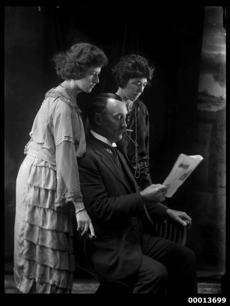Group portrait featuring two ladies and a man reading a paper (7089495825)