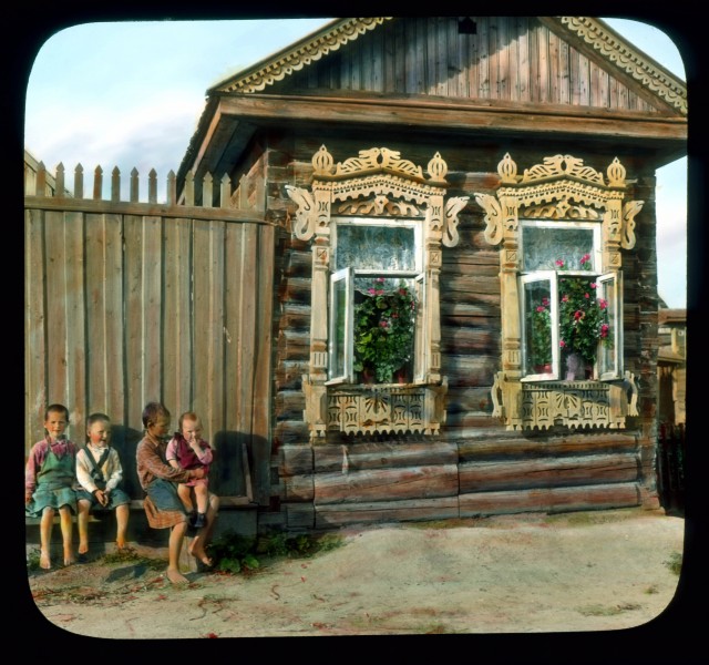 Saint Petersburg children in front of a house with elaborately-carved window frames, near Leningrad