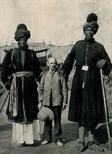 Two Kashmir giants, and their exhibitor, Professor Ricalton. Wellcome V0007379