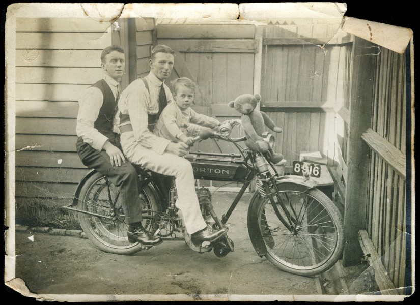 Two men and a young boy (Tom Wild) on a motorbike, with a teddy bear sitting on the handle bars (10544730075)