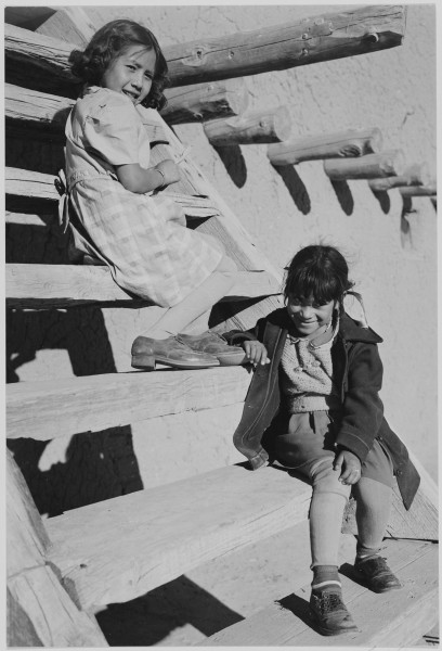 Two young girls sitting on steps. At San Ildefonso Pueblo, New Mexico, 1942.
