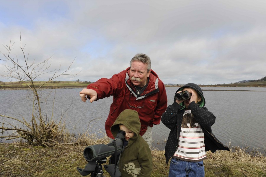 Two children and a man view wildlife