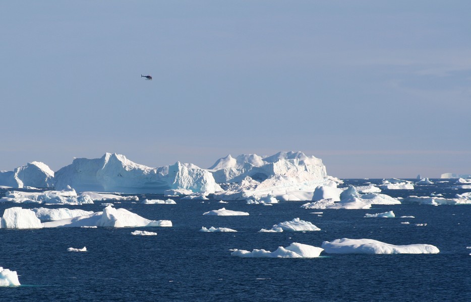 Helicopter flying around the icebergs at Cape York