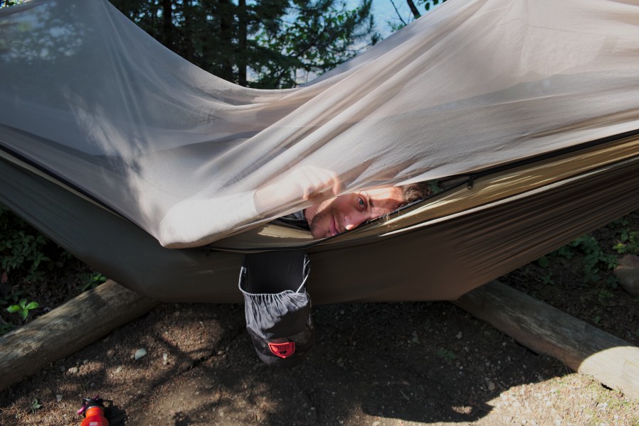 Man peeking out of a hammock in Bowron Lake Provincial Park campsite 6 (DSCF2208)