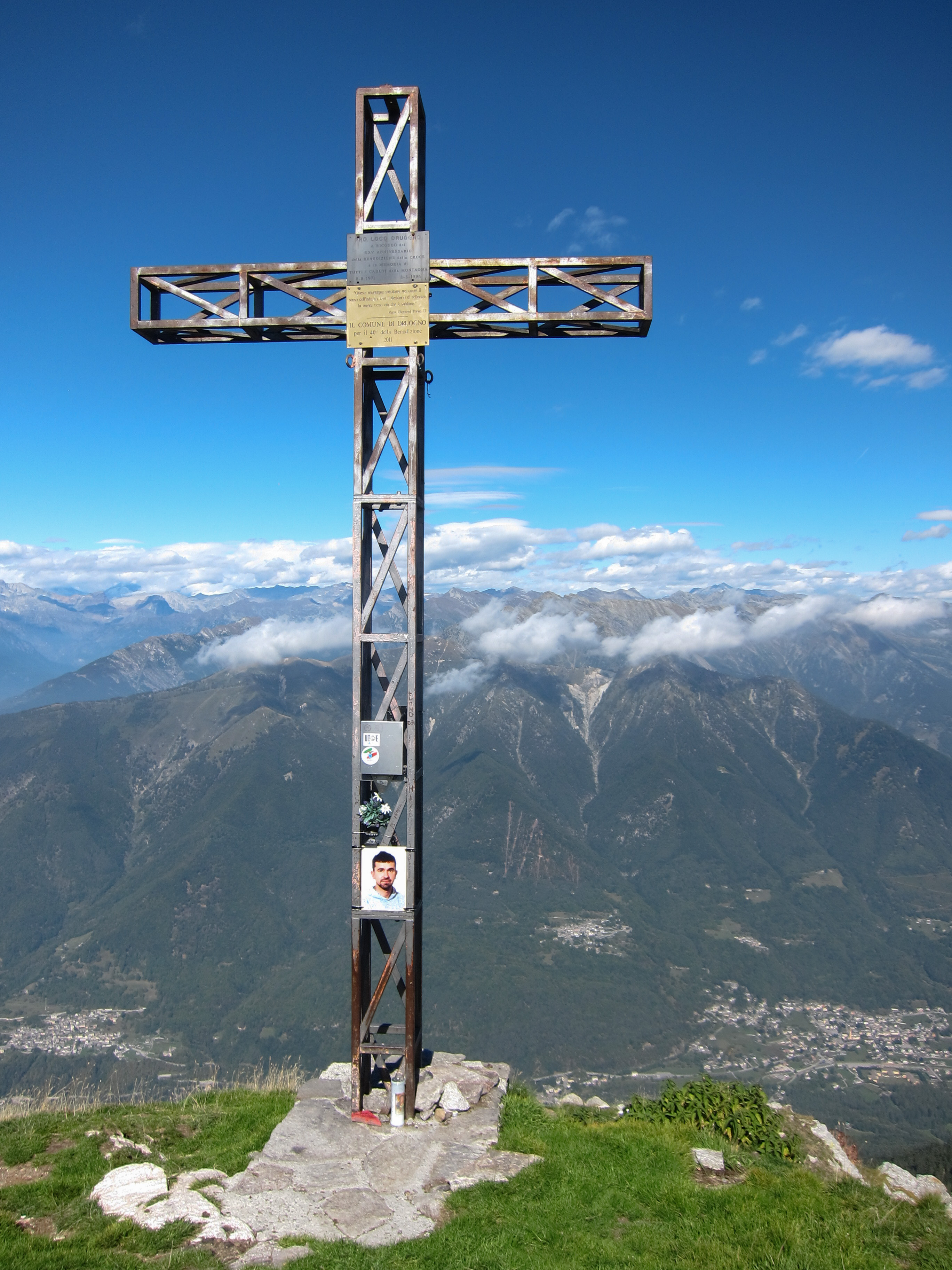 Metal cross on top of mount Pizzo Ragno (2.289 m.a.s.l.) and view of Val Vigezzo - VB Piedmont, Italy - 2018-09-23