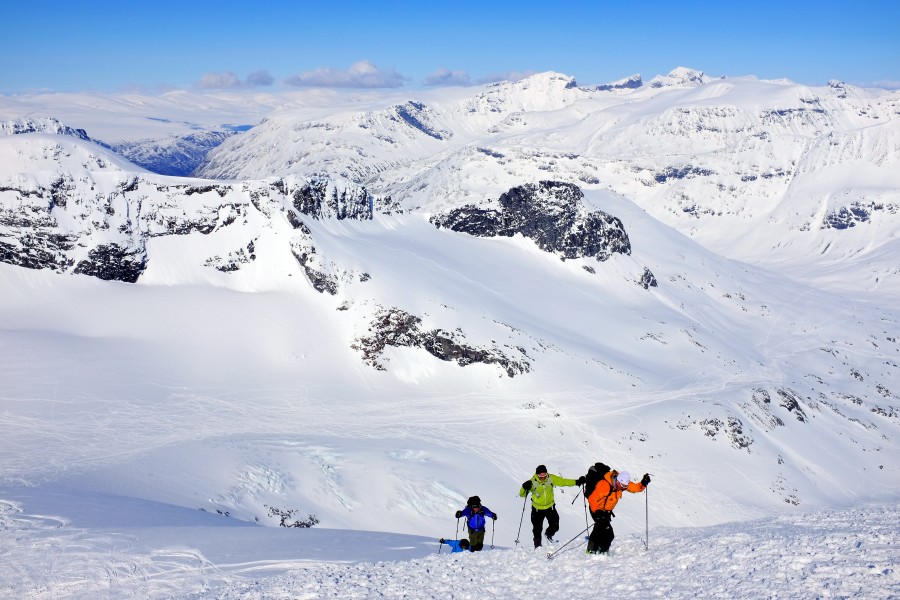 Off-piste skiers ready for takeoff from Storebjørn peak in Jotunheimen