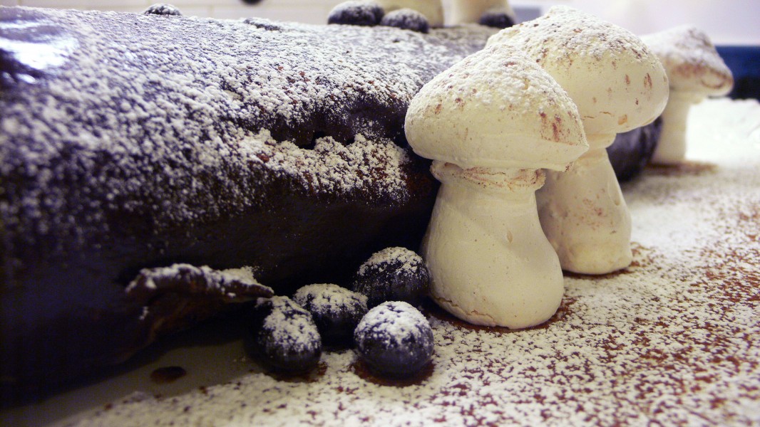 Bûche de Noël with meringue mushrooms sprinkled with confectioner's sugar