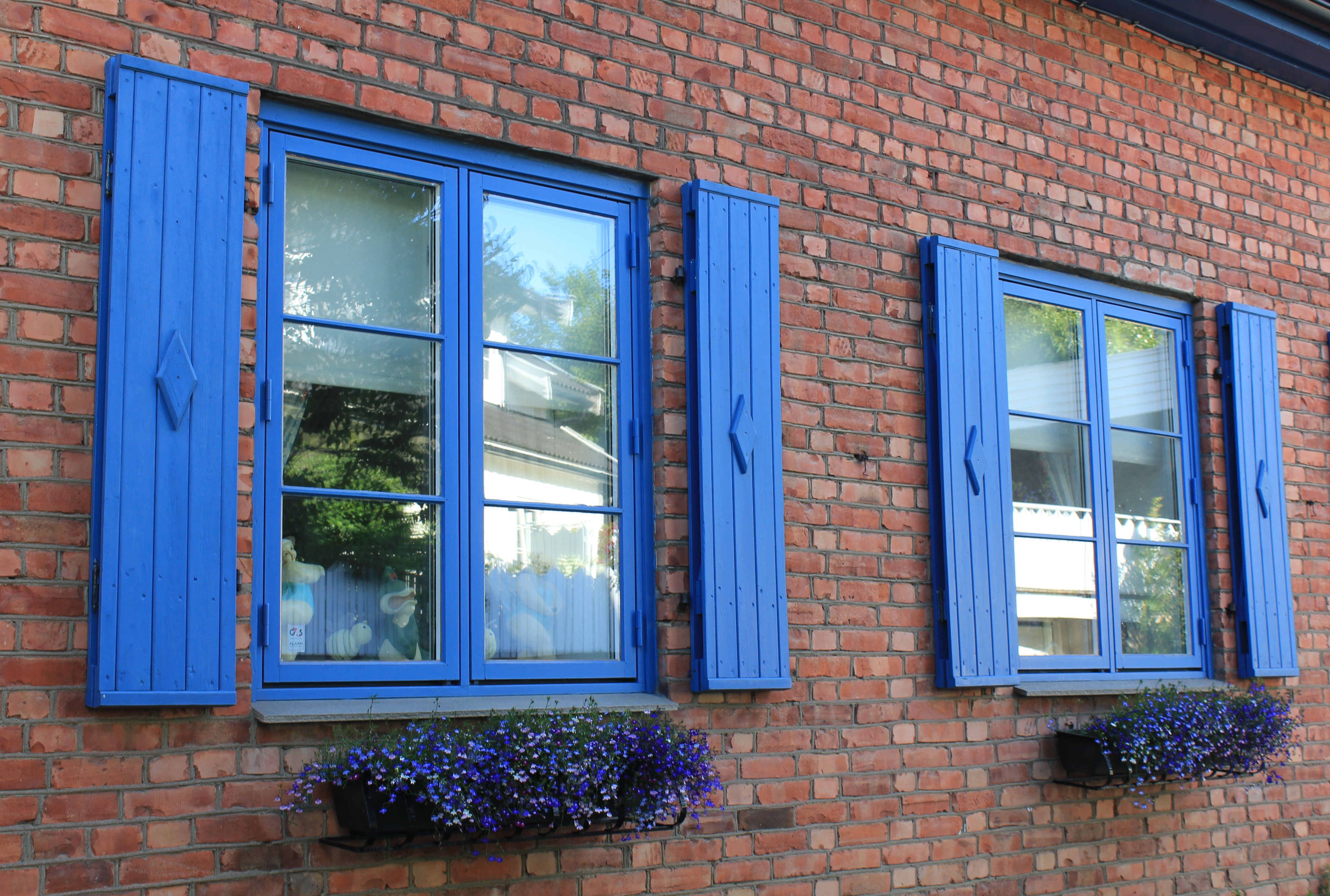 Blå vinduslemmer på gammelt murhus