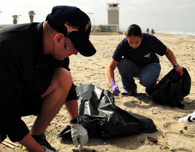 US Navy 100424-N-0808V-022 Logistics Specialist 1st Class Marcos Maldonado and Logistics Specialist 1st Class Lillian Morales olunteer during the Creek to Bay Clean-up to collect trash along Silver Strand State Beach