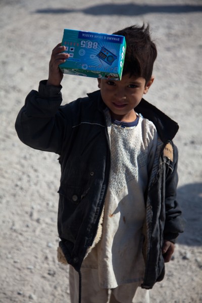 A boy in Ananzai village, Kandahar province, Afghanistan, holds up a handheld radio he received from U.S. Soldiers attending the opening of the village's new school Dec. 26, 2011 111226-A-VB845-044