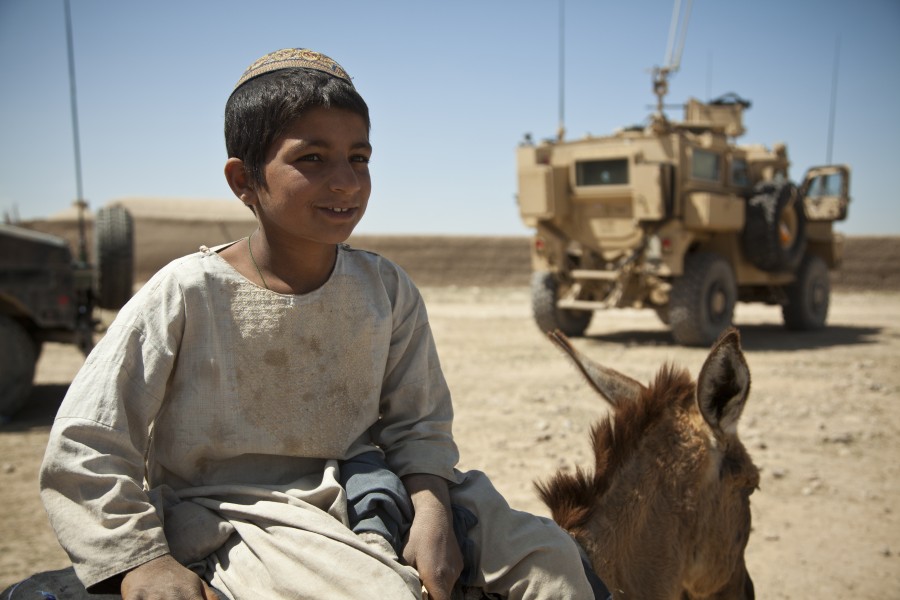 A boy watches U.S. Special Operations Marines who are providing security for Afghan National Army special forces soldiers and Afghan Local Police members building a checkpoint in Helmand province, Afghanistan 130403-M-BO337-144